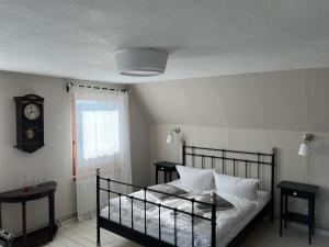 a bedroom with a bed and a clock on the wall at Seeblick Cottage in Ziemitz