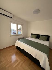 a bedroom with a large bed and a window at Apartment Darna in Neum