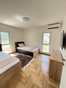 a room with two beds and a television in it at Apartment Darna in Neum