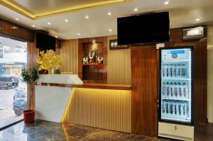 a bar in a restaurant with a television on the wall at Hotel Sayba Executive in Pune