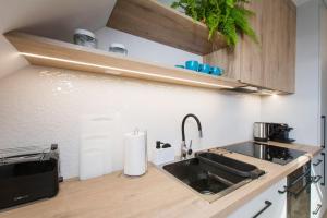 a kitchen with a sink and a microwave at Dom Gościnny Ogrodowa in Wiślinka