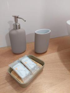 un plateau avec un distributeur de savon et une tasse sur une table dans l'établissement Corso Perrini, 68, à Fasano