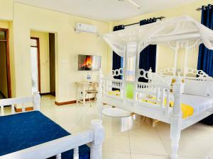 a bedroom with a white bed with a canopy at Elna's Nyali - Work & Unwind - Pool, Sea Views, AC & Fast Wi-Fi in Mombasa