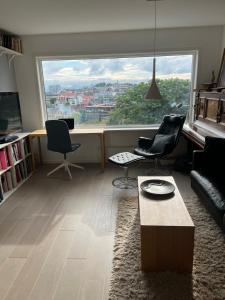 a living room with chairs and a large window at ONS 2024, sentrum Stavanger in Stavanger