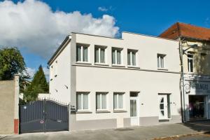 a white building with a black gate at gîte en rdc A 200 m tgv et de la fac A 400 m des places 250 places de parking face au logement in Arras