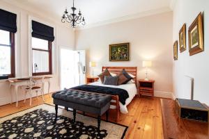 a bedroom with a bed and a chair at Carmichael House Boutique Hotel in Cape Town