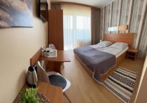 a bedroom with a bed and a table and a desk at Willa Balticus in Władysławowo