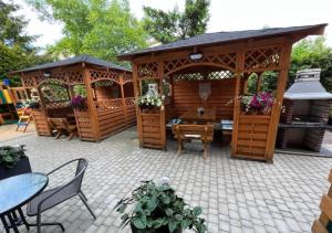 a wooden gazebo with a table and chairs at Willa Balticus in Władysławowo