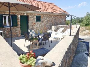 eine Terrasse mit Tisch und Stühlen und einem Sonnenschirm in der Unterkunft Apartment in Jusupi near Mala Paklenica Park in Jukič