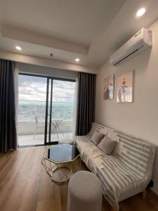 a living room with a couch and a large window at TMS Quy Nhơn-Chuee Homestay in Quy Nhon +8 photos