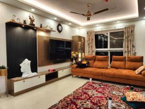 a living room with a couch and a flat screen tv at Elite 3BHK- 19th Floor Only for Family in Bengaluru