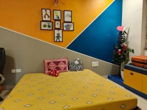 a bedroom with a yellow bed and a christmas tree at Elite 3BHK- 19th Floor Only for Family in Bengaluru