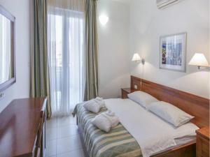a bedroom with a bed and a desk and a window at Apartment in Veli Losinj by the Sea in Veli Lošinj
