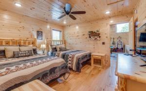 a log cabin bedroom with two beds and a ceiling fan at The Foxtail Lodge in Gatlinburg +40 photos