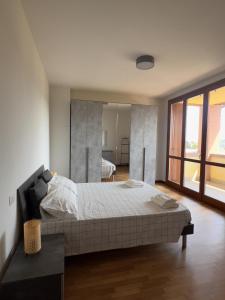 a bedroom with a large bed and a large window at La casa del sole in Langhirano