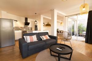 a living room with a couch and a table at AfroBoHome, Expérience Atypique, clim, 2 à 6 personnes, Proche centre Nîmes, Garage clos in Nîmes