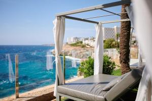 a bedroom with a bed and a view of the ocean at Alua Calas de Mallorca Resort in Calas de Mallorca