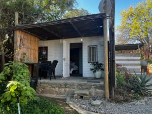a small white house with a porch with a table at Karoo Soul in Oudtshoorn