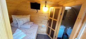 a small room with a bed and a television at La Casute in Apuseni in Gârda de Sus