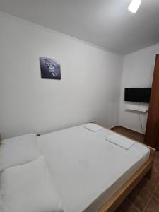 a white room with a bed and a tv at Apartman Turkovic in Herceg-Novi