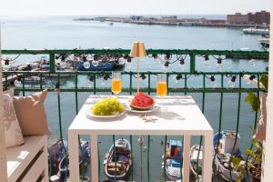 un tavolo con frutta su un balcone con vista sull'acqua di La Finestra Sul Mare Central Apartment Vista mare ad Anzio
