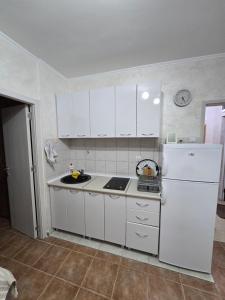 a kitchen with white cabinets and a white refrigerator at Apartman Turkovic in Herceg-Novi