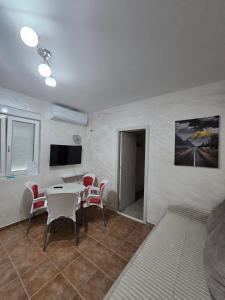 a living room with a table and chairs and a television at Apartman Turkovic in Herceg-Novi