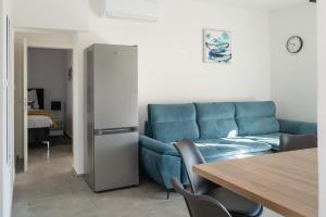 Una sala de estar con un sofá azul y una mesa. en Lux Apartments Villa Navalia, en Novalja