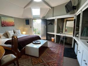 a bedroom with a bed and a table in it at Karoo Soul in Oudtshoorn