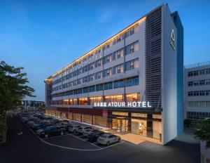 厦门厦门北站嘉庚体育馆亚朵酒店的一座大楼，停车场里停满了汽车