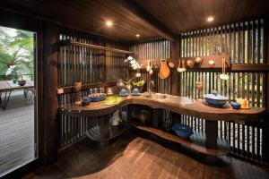 a kitchen with a sink and a wooden wall at Batak Legacy, A Jungle Hideaway in Tabanan