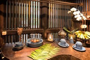 a table with food on it with bananas and candles at Batak Legacy, A Jungle Hideaway in Tabanan +33 photos
