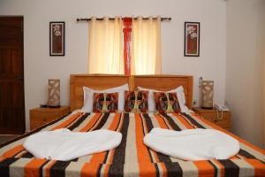 um quarto com uma cama grande e 2 almofadas em Villa Baywalk Goa em Morjim