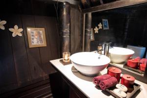 a bathroom with a sink and two mirrors at Batak Legacy, A Jungle Hideaway in Tabanan