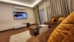 a living room with a couch and a tv at Sphinx Luxor Apartment in Luxor