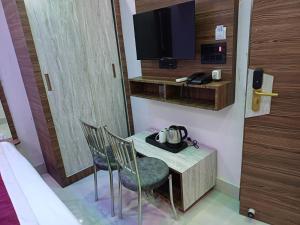 a room with a table and chairs and a tv at Hotel Shobhani in Deoghar