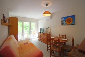 a living room with a table and a dining room at Basic Comfort Studio POBLAT TIPIC 0167 in Empuriabrava