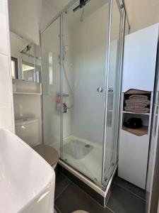 a bathroom with a glass shower and a toilet at Sublime Appart Vue mer Piscine Clim in La Grande-Motte