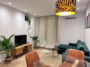 a living room with a green couch and a television at Apartment San Pietro in Supetar