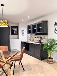 a kitchen with black cabinets and a glass table at Apartment San Pietro in Supetar