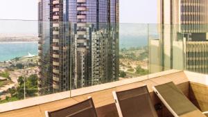 a balcony with chairs and a view of a tall building at Royal Home in Abu Dhabi