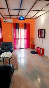 a living room with a couch and a flat screen tv at Résidence NKOA in Yaoundé
