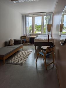 un soggiorno con divano, letto e sedia di CityLoginn a Närpiö
