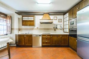 a kitchen with wooden cabinets and a refrigerator at Abánades in Melgar de Fernamental