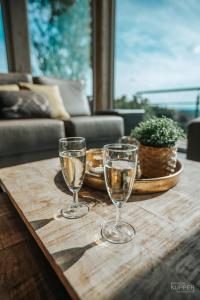 two wine glasses sitting on a wooden table at Le Noir Flohay 30 pers - Malmedy, vue, wellness in Malmedy