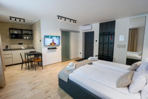 a large bedroom with a large bed and a kitchen at Gyulai Várpark Apartman in Gyula