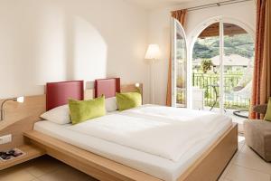 a bedroom with a large white bed with a window at Garden Residence in Lana +36 photos