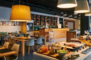 a restaurant with tables and chairs and a kitchen at TOC Hostel Barcelona in Barcelona