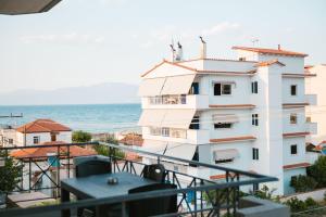 a white building with a view of the ocean at Olympio Apartments in Xylokastron