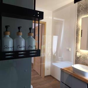 Baño con 2 botellas de jabón y lavamanos en Apartament Podgórzyn, en Podgórzyn